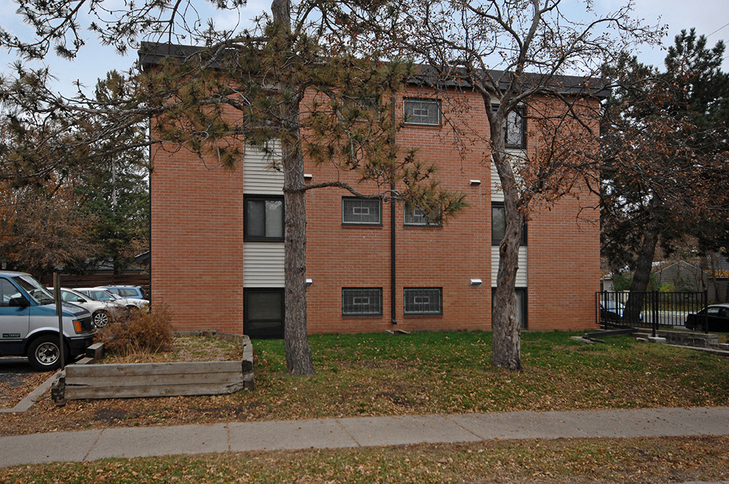 a brick building with trees in front of it